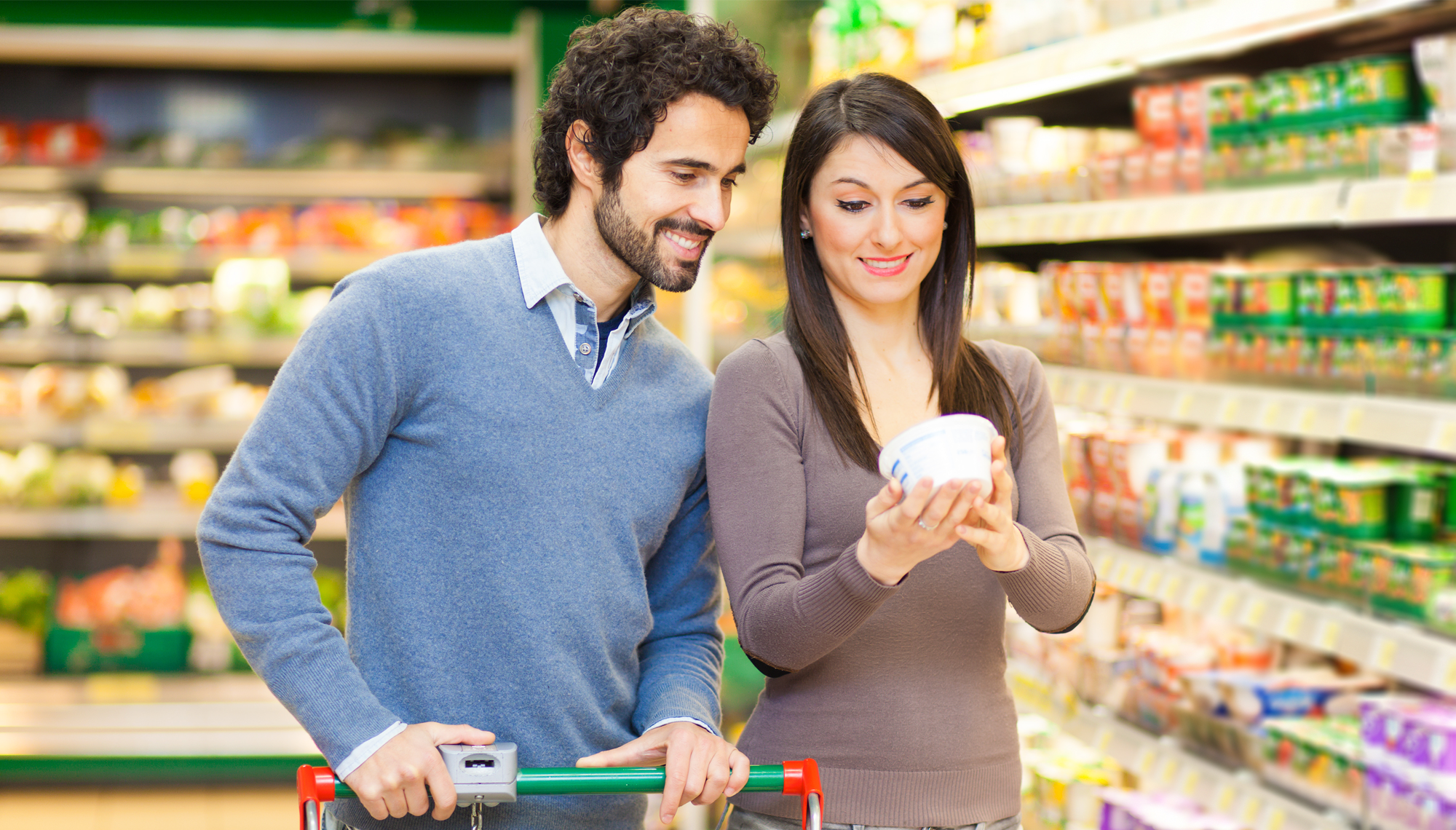 A couple in grocery store reading a food label