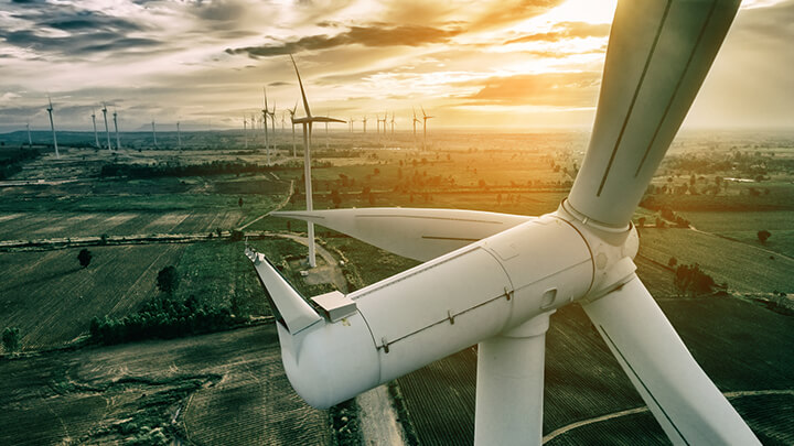Wind Turbines over an open field at sunset