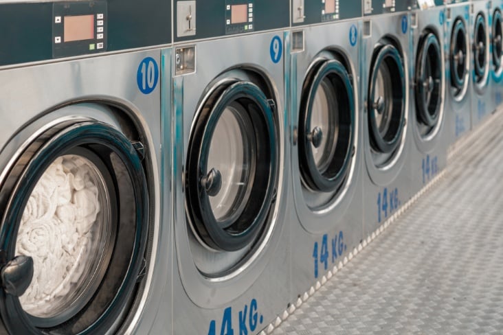 Row of washing machines in public laundry.