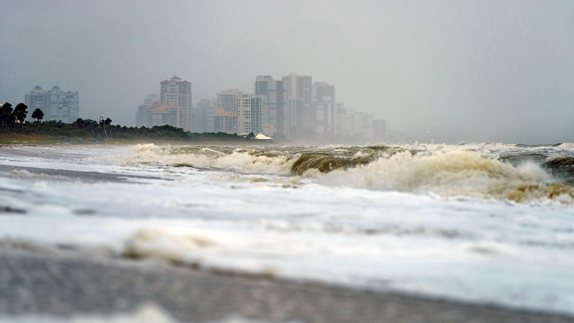 USA, Florida, Naples, Vanderbilt Beach, waves and spray after hurricane Harvey in front of hotel buildings